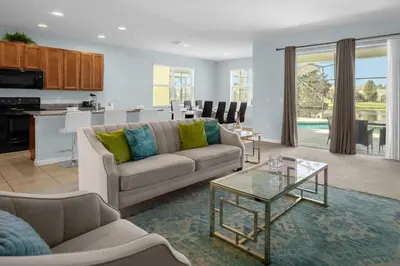 a living room with a couch and a table at Upstay - Resort Home w Cinema Pool & Lake View in Kissimmee