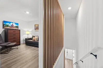 a living room with a couch and a tv on a wall at Modern Townhome 10min to Disney in Kissimmee
