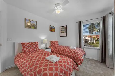 a bedroom with two beds and a window at Casa Vista Lago c/ Piscina Privada – Próx. Disney in Kissimmee