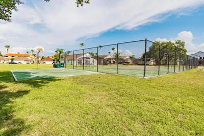 a tennis court with a net in a field at Casa Vista Lago c/ Piscina Privada – Próx. Disney in Kissimmee