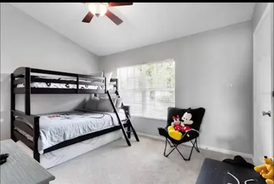 a bedroom with a bunk bed and a chair at Relaxing vacation resort villa in Orlando