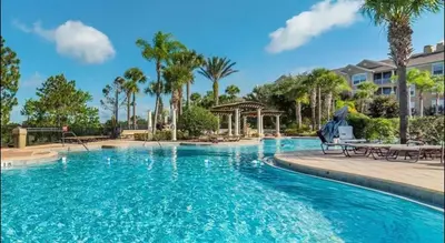 a pool at a resort with palm trees and a gazebo at Relaxing vacation resort villa in Orlando