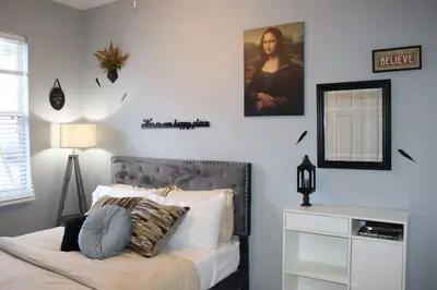 a bedroom with a bed with a mirror and a dresser at Level Up Your Vacation Stylish Home Near Disney in Kissimmee