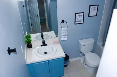a blue bathroom with a sink and a toilet at Level Up Your Vacation Stylish Home Near Disney in Kissimmee