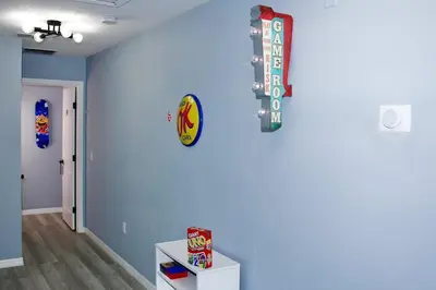 a room with a blue wall with a sign on the wall at Level Up Your Vacation Stylish Home Near Disney in Kissimmee