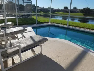 a swimming pool with two lounge chairs next to it at Holiday Hideout by Paradise Resort Vacations in Orlando