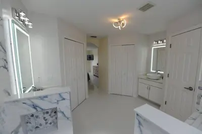 a white bathroom with a tub and a sink and a mirror at Ruby-Rose Retreat by Paradise Resort Vacations in Kissimmee