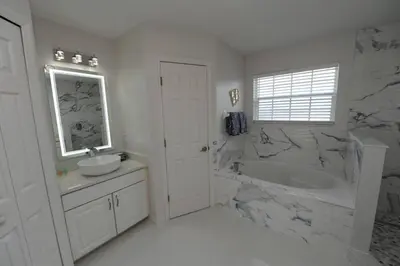 a white bathroom with a tub and a sink and a bath tub at Ruby-Rose Retreat by Paradise Resort Vacations in Kissimmee