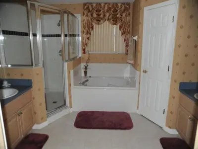 a bathroom with a tub and a shower and a sink at Tranquil Waters Haven by Paradise Resort Vacations in Kissimmee