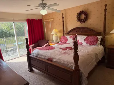 a bedroom with a bed and a chair and a window at Tranquil Waters Haven by Paradise Resort Vacations in Kissimmee