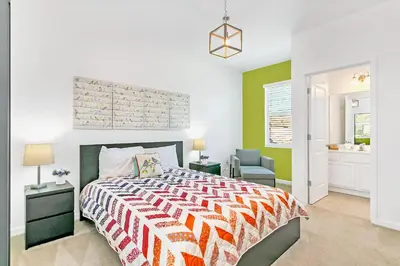 a bedroom with a bed and a chair in it at UPSTAY- 10BR Mansion wPrivate Pool and Games Room in Kissimmee