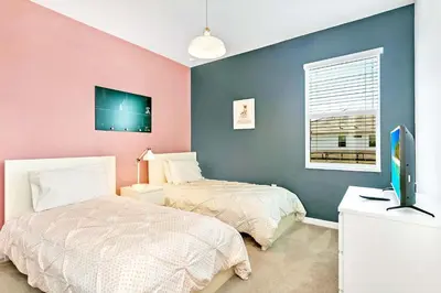 a bedroom with two beds and a television in it at UPSTAY- 10BR Mansion wPrivate Pool and Games Room in Kissimmee