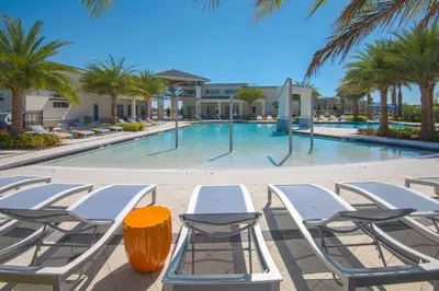 a pool with chaise lounge chairs and a table at UPSTAY- 10BR Mansion wPrivate Pool and Games Room in Kissimmee