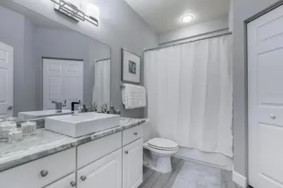 a white bathroom with a sink and a toilet at 4 Bedrooms 3 Bathrooms Lucaya Village 2-101 in Kissimmee