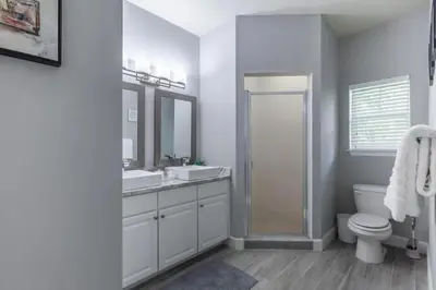 a bathroom with a toilet and a sink and mirror at 4 Bedrooms 3 Bathrooms Lucaya Village 2-101 in Kissimmee