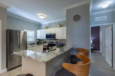 a kitchen with a stainless steel refrigerator and cabinets at 4 Bedrooms 3 Bathrooms Lucaya Village 2-101 in Kissimmee