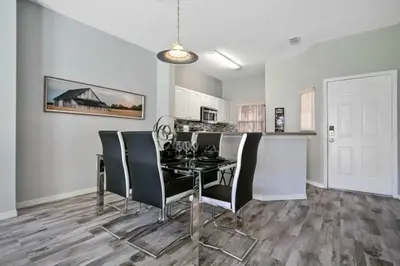 a dining room with a black table and chairs at Casa 3 Quartos no Lake Berkley Resort in Kissimmee