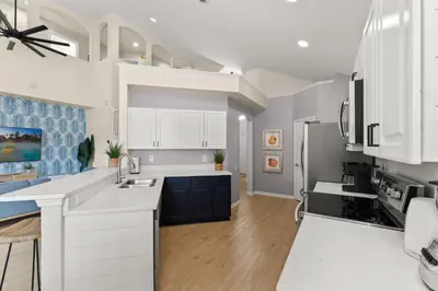 a kitchen with white cabinets and a white counter top at Tiki Palms Play and Pool Near Disney in Kissimmee