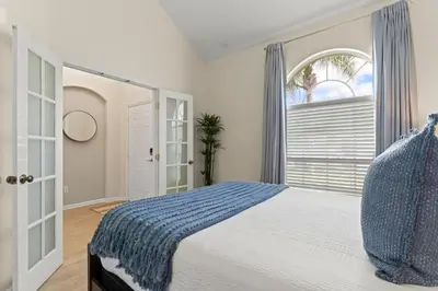 a bedroom with a large bed and a window at Tiki Palms Play and Pool Near Disney in Kissimmee