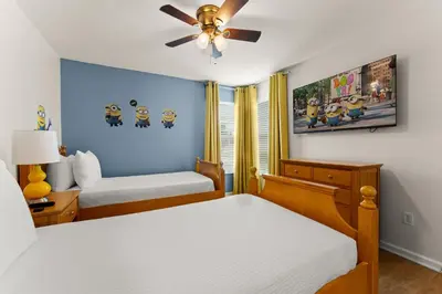 a bedroom with two beds and a ceiling fan at Tiki Palms Play and Pool Near Disney in Kissimmee