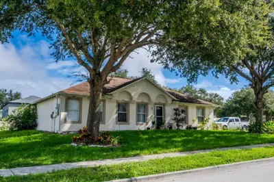 a white house with trees in front of it at Flint and Kingscrest, LLC - Private Rooms in Shared Home in Orlando