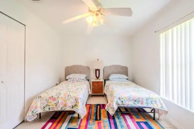 a bedroom with two beds and a ceiling fan at Flint and Kingscrest, LLC - Private Rooms in Shared Home in Orlando