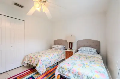 a bedroom with two beds and a ceiling fan at Flint and Kingscrest, LLC - Private Rooms in Shared Home in Orlando