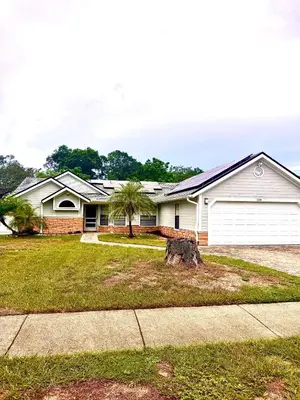 a house with a tree in the front yard at Tropical Paradise in Orlando
