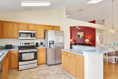 a kitchen with wooden cabinets and stainless steel appliances at Indian Creek Vacation Home Close to Disney in Orlando
