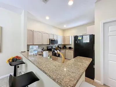 a kitchen with a counter and a black refrigerator at Walk to Silver Spurs Rodeo and Heritage Park in Kissimmee