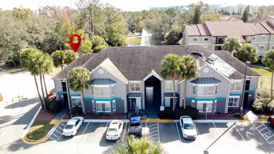 an aerial view of a house with cars parked in a parking lot at Parkway Palms Resort 1 bed condo mins to Disney. in Orlando