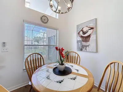 a dining room table with a vase of flowers on it at Emerald Island 4Bd/3Ba Villa, 3 miles to Disney in Kissimmee