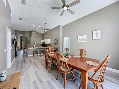 a dining room and kitchen with a wooden table and chairs at Terra Verde Resort 4 Bed Pool/Spa Villa in Kissimmee