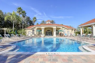 a swimming pool in front of a house at Emerald Island Resort 6 Bed Pool & Spa in Kissimmee
