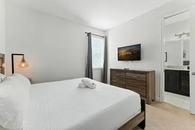 a bedroom with a white bed with a stuffed animal on it at 7416 Encore Reunion poolspa 11 guests 5 bdrs BBQ in Orlando
