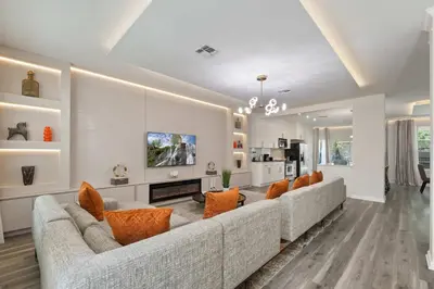 a living room with a long couch and orange pillows at 2540HS 6Bedrooms Disney Villa Sleeps 20 with Pool & Spa in Orlando