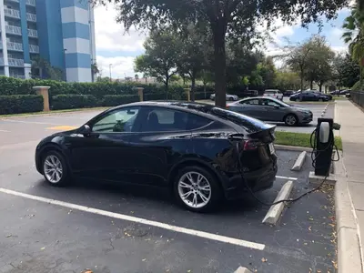 a black car is plugged into a parking meter at Central Location to all Parks and Convention center in Orlando