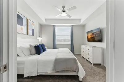 a bedroom with a white bed and a ceiling fan at Elegant 2BR in Storey Lake Top Location in Kissimmee