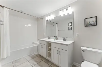 a white bathroom with a sink and a toilet at Elegant 2BR in Storey Lake Top Location in Kissimmee