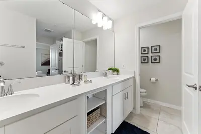 a white bathroom with a sink and a mirror at Storey Lake condos by Une Homes in Kissimmee