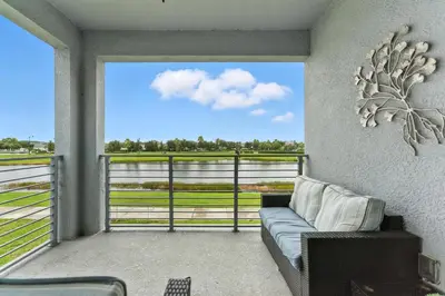 a living room with a couch on a balcony at Storey Lake condos by Une Homes in Kissimmee