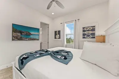 a white bedroom with a bed with a scarf on it at The Flamingo Nest - Kid Friendly in Orlando