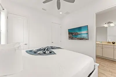 a white bedroom with a bed and a ceiling fan at The Flamingo Nest - Kid Friendly in Orlando