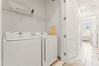 a white laundry room with a washer and dryer at The Flamingo Nest - Kid Friendly in Orlando