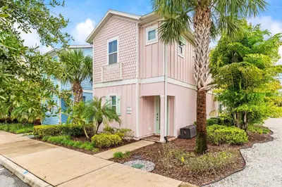 a pink house with palm trees and a sidewalk at The Flamingo Nest - Kid Friendly in Orlando