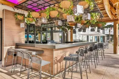 a bar with a row of stools in a restaurant at The Flamingo Nest - Kid Friendly in Orlando
