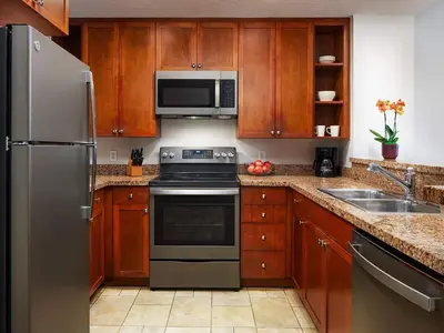 a kitchen with stainless steel appliances and wooden cabinets at Sheraton Vistana Villages 1BR Apartment with Resort Access in Orlando