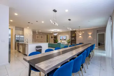 a conference room with a long table and blue chairs at Stunning Mansion 15 ensuites in Kissimmee