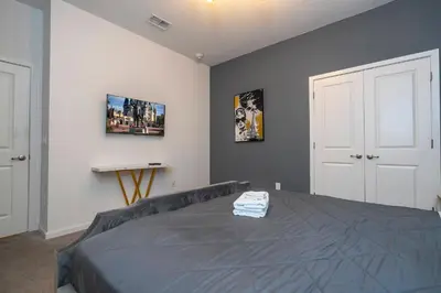 a bedroom with a bed and a wall with pictures at Stunning Mansion 15 ensuites in Kissimmee