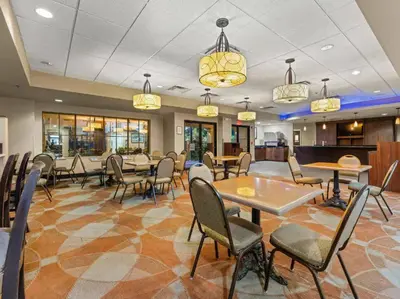 a dining room with tables and chairs and chandeliers at SkySuite 5min to Universal Park in Orlando